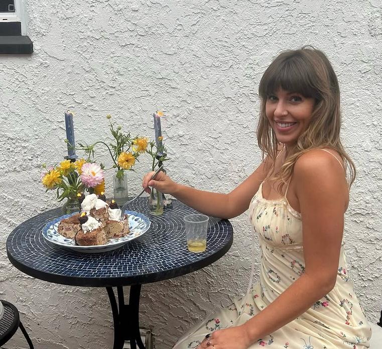 Becky Litwiller sitting at a table with flowers and cake